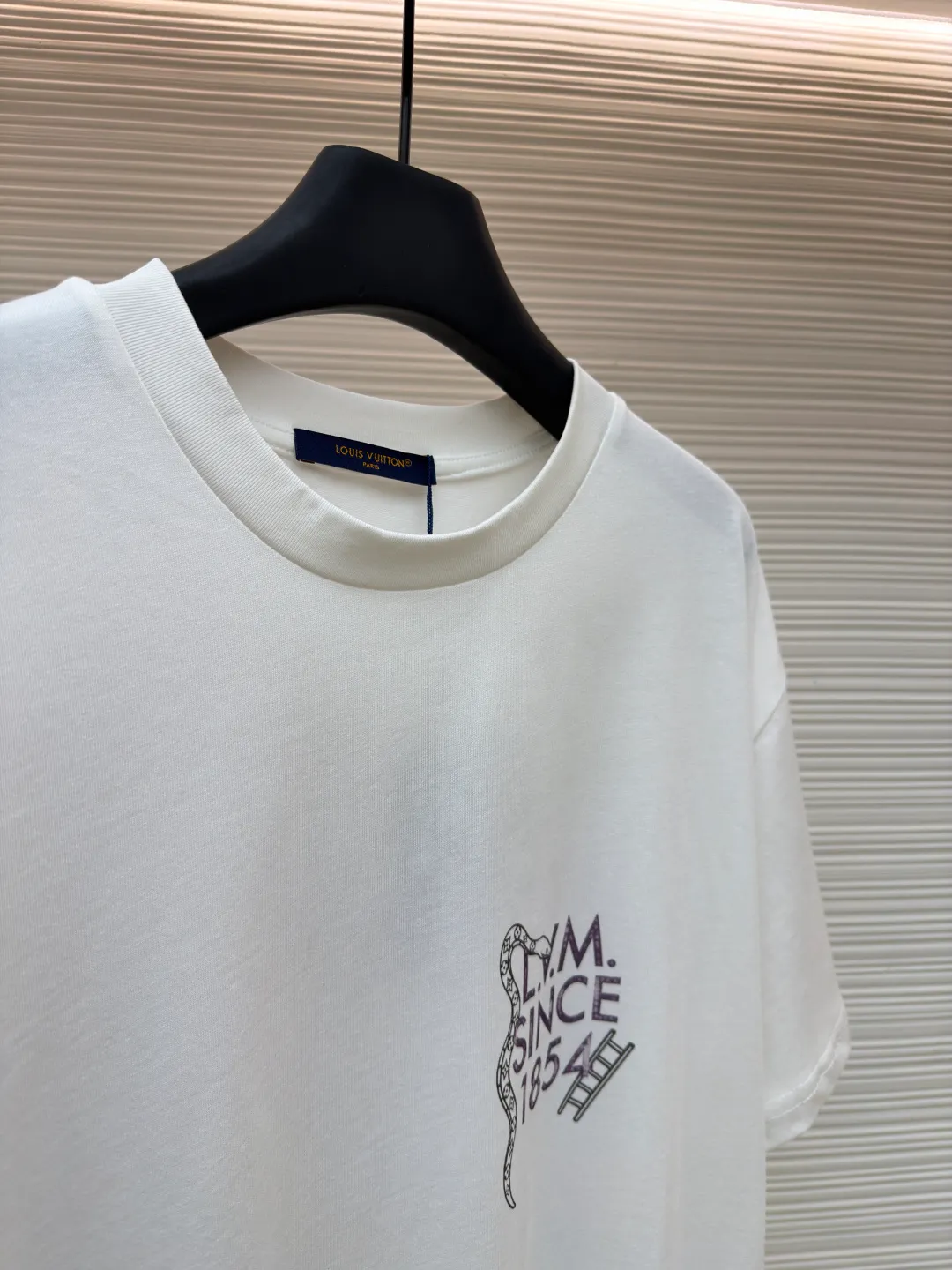 LOUIS VUITTON round neck printed short-sleeved T-shirt ●Original version: Purchased and developed at 7450 ●Item number: 1682214-A10 ●Fabric: cotton fabric ●Technology: Printing ●Color: white ●Version: fitted version ●Weight: about 260 grams ●Size: S-M-L-XL ●Description: This printed short-sleeved T-shirt is made using high-end garment technology. The fabric is made of 230g heavyweight double-strand combed cotton. It is treated with an enzyme washing process to make the cotton soft to the touch and not easy to pill or deform, while retaining the breathability and skin-friendly properties of cotton. The back theme printing uses a composite process of digital direct inkjet printing and screen printing. First, digital direct inkjet printing is used to restore the color gradation and delicate texture of the pattern, and then screen printing is used to outline the outline of the pattern, which increases the color firmness of the printing by 30% and does not fade or crack after repeated washing. The neckline is hemmed with two stitches and is paired with high-elastic rib fabric, which is resistant to pulling and does not deform after long-term wear. The side seams and shoulder seams of the body are sewn with embedded clip technology, and the stitching is fine and smooth. The overall shape is created through three-dimensional tailoring to create a loose shoulder drop effect, taking into account both wearing comfort and stiffness. The overall wiring is straight and delicate, the fabric is comfortable and soft, and the color is consistent without color difference. It can be matched with the same style to create a fashionable look and control various occasions. Customized accessories, complete with three standards, same style for men and women!